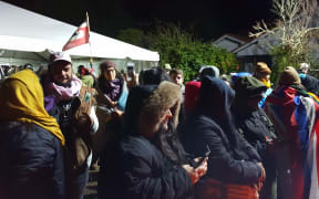 People gathered at Ihumātao on Monday evening after police deployed more officers to the scene.