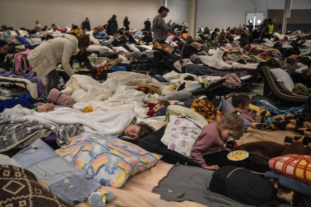 People rest in a temporary shelter for Ukrainian refugees, located near the Polish-Ukrainian border in a former shopping center in Przemysl, Poland, on March 8, 2022.