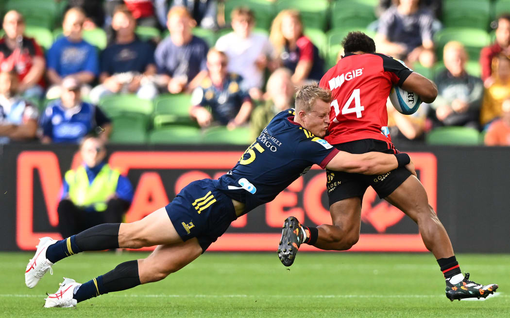 Sam Gilbert of the Highlanders (left) tackles Sevu Reece of the Crusaders.