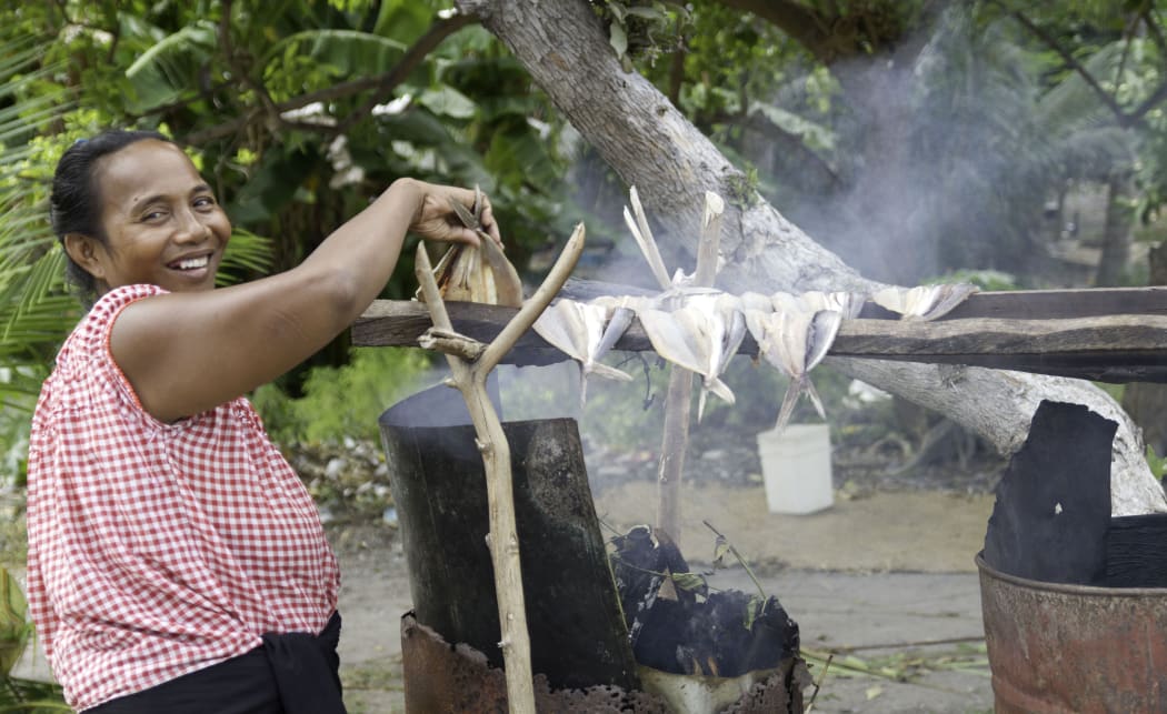 A Kiribati woman smoking fish