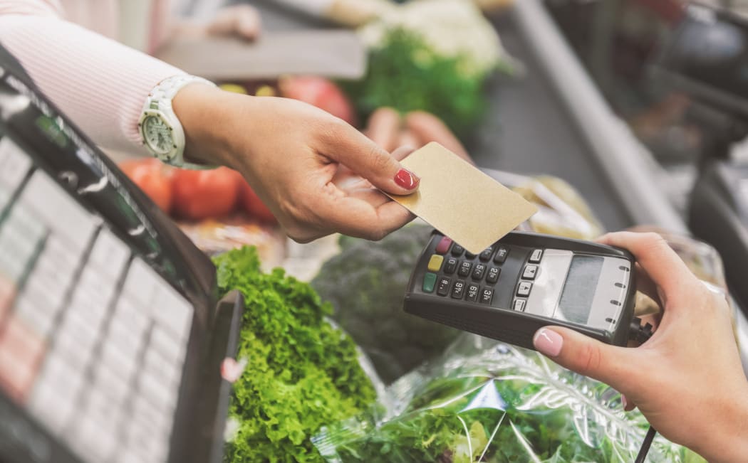 Woman is going to use contactless means of payment in supermarket. Close up of female hands holding necessary cash equipment