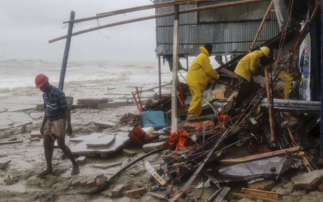 Bangladeshi rescue workers search for survivors after Cyclone Roanu hit the southern Chittagong district.