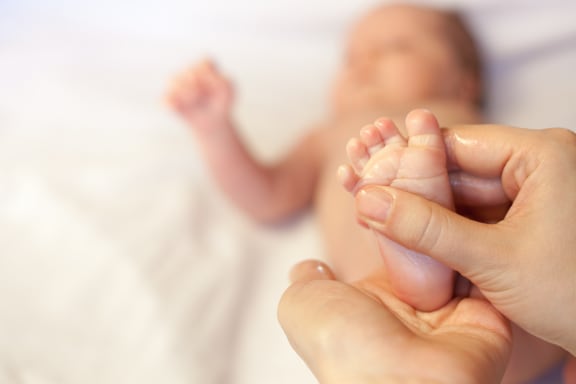 Mother massaging baby