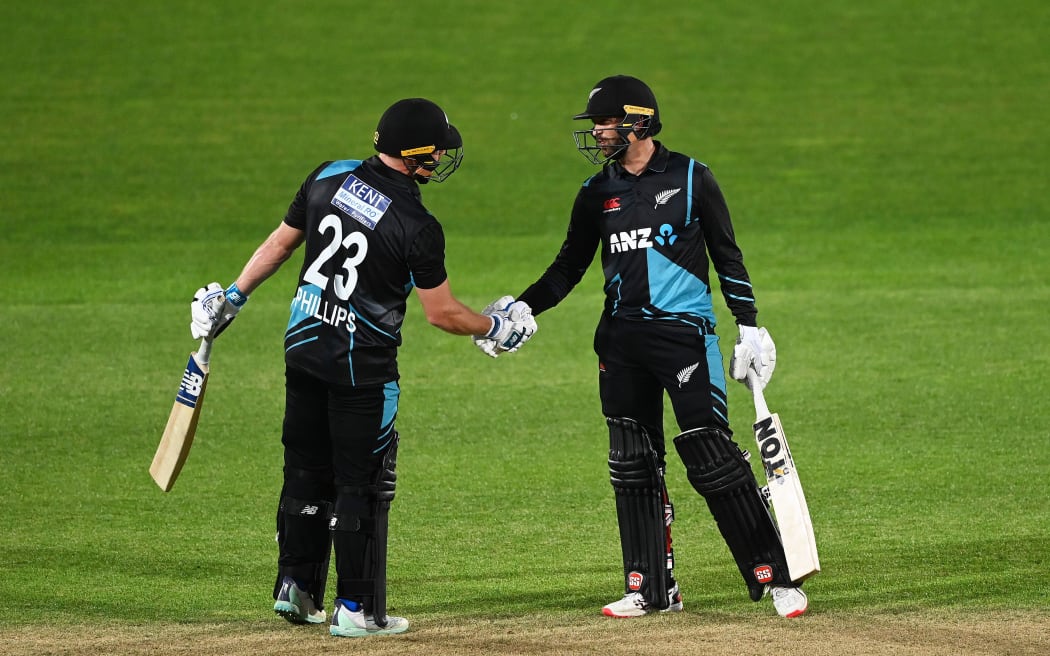 New Zealand’s Glenn Phillips (L) congratulates Devon Conway for scoring fifty runs during the 3rd T20 cricket international against India in Napier, 2022.