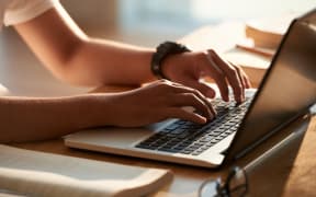 Hands of person typing on laptop keyboard