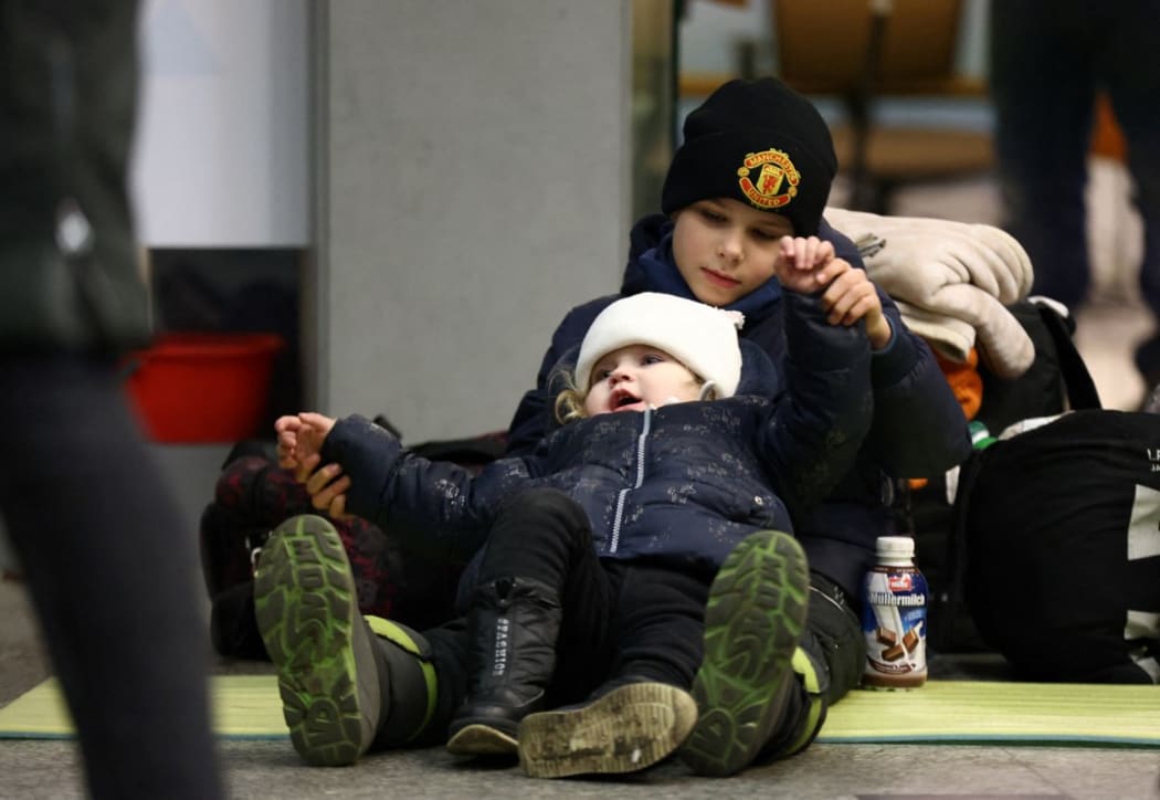 Evacuees of Ukraine sit at Krakow station in Krakow, southern Poland on March 6, 2022. Lots of Ukrainians are heading to Poland to escape the war. Russian President Vladimir Putin