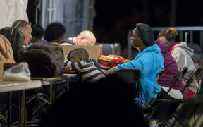 Refugees speak to Canadian officials at a processing centre after crossing the border from the United States