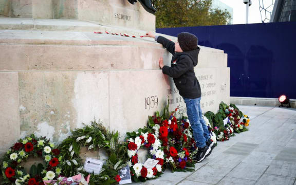 A child laying poppies in Christchurch.