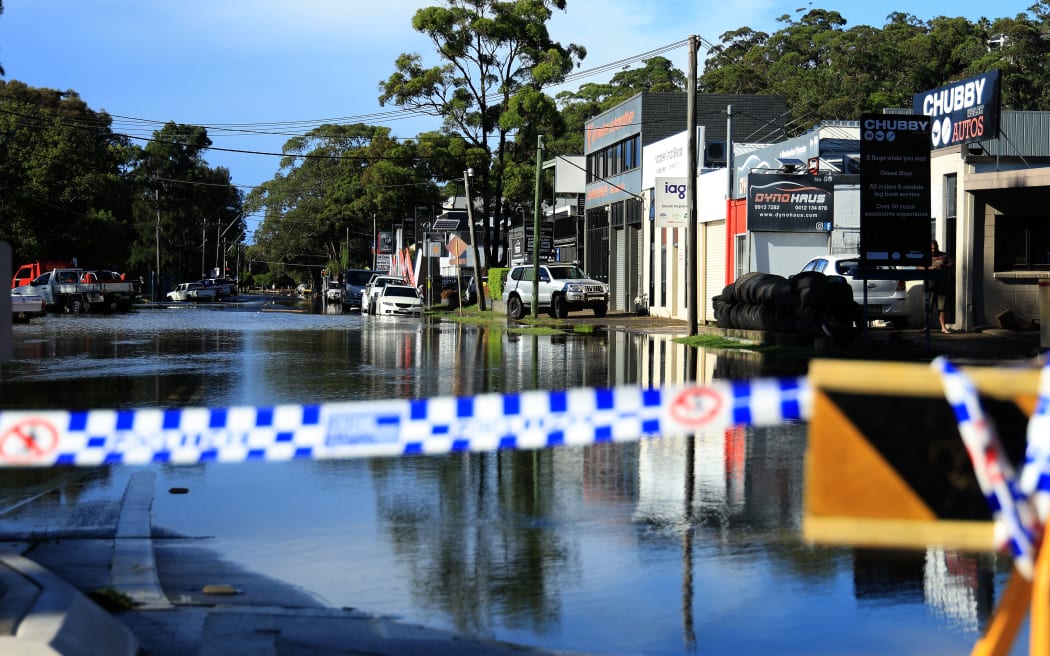 A flooded road in the Sydney suburb of North Narrabeen on 6 April, 2024, after heavy rain hit New South Wales state. (Photo by Glenn Nicholls / AFP)