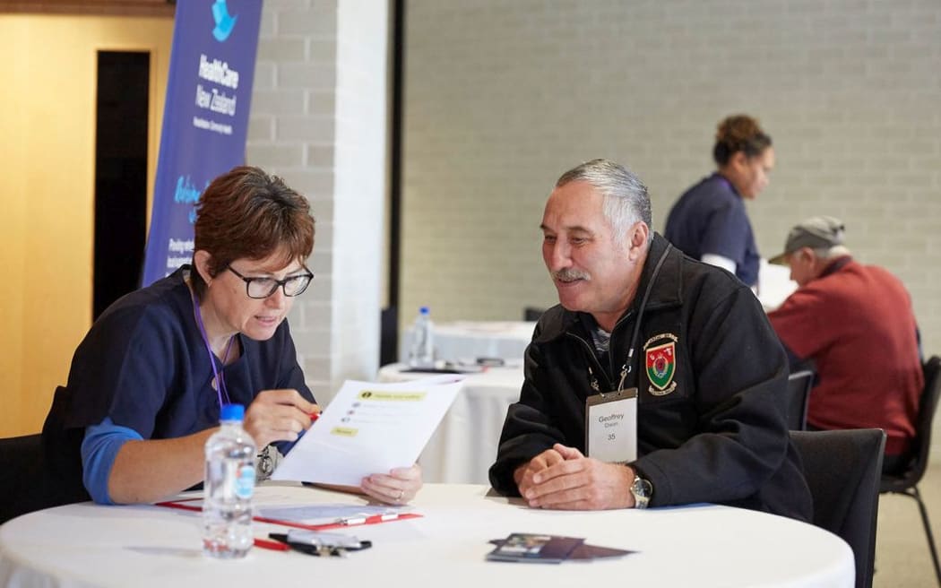 A Vietnam veteran completing a quick health and wellbeing assessment with a healthcare professional from HealthCare New Zealand