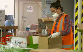 KidsCan workers fill boxes to deliver to families in need under lockdown.