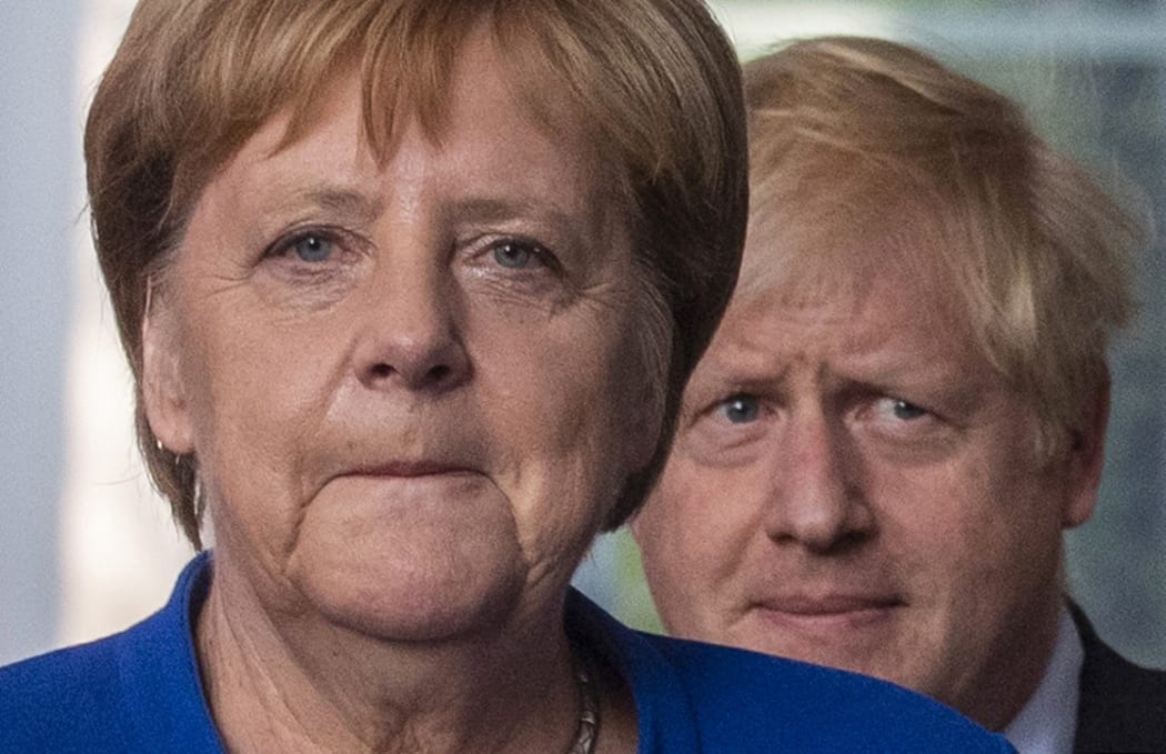 German Chancellor Angela Merkel (L) and British Prime Minister Boris Johnson arrive for a press conference at the Chancellery.
