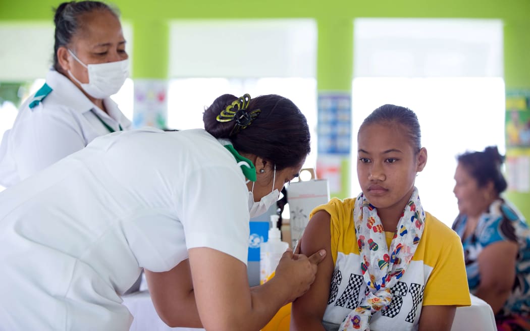 This picture released from UNICEF Samoa shows a girl receiving a vaccine during a nationwide campaign against measles in the Samoan town of Le'auva'a.