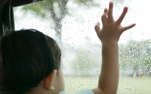 A toddler looking out the window.
