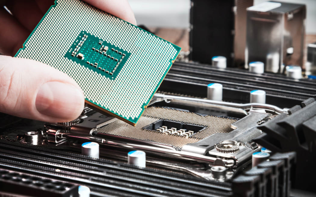 CPU in hand before installation into the motherboard