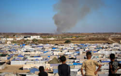 Children watch from atop a promontory overlooking shelters for people displaced by war, as smoke billows in the background near the Nuseirat camp for Palestinian refugees in the central Gaza Strip on June 19, 2026. Palestinian Islamist movement Hamas on Monday hailed a deal between the United States and Iran, expressing hope it would help put an end to violence in the Gaza Strip. Israel and Hamas trade near-daily accusations of truce violations and the Gaza Strip remains gripped by bloodshed as progress on permanently ending the war remains stalled. (Photo by Eyad Baba / AFP)