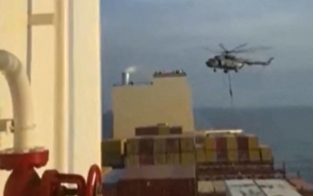 This image grab taken from a UGC video posted on social media on April 13, 2024 shows Iran's Revolutionary Guards rappelling down onto a container ship named, MSC Aries, near the Strait of Hormuz. Iran's Revolutionary Guards on Saturday seized a container ship "related to the Zionist regime (Israel) in the Gulf," state media reported, as tensions soar in the region. (Photo by AFP) / XGTY/RESTRICTED TO EDITORIAL USE - MANDATORY CREDIT AFP -  SOURCE: ANONYMOUS - NO MARKETING - NO ADVERTISING CAMPAIGNS -  DISTRIBUTED AS A SERVICE TO CLIENTS - NO ARCHIVE - AFP IS NOT RESPONSIBLE FOR ANY DIGITAL ALTERATIONS TO THE PICTURE'S EDITORIAL CONTENT / “The erroneous mention[s] appearing in the metadata of this photo by - has been modified in AFP systems in the following manner: [2024] instead of [2023]. Please immediately remove the erroneous mention[s] from all your online services and delete it (them) from your servers. If you have been authorized by AFP to distribute it (them) to third parties, please ensure that...