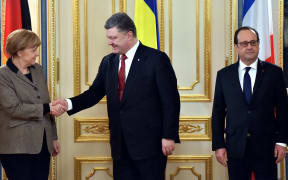 Ukrainian President Petro Poroshenko (C) shakes hands with German Chancellor Angela Merkel (L). French President Francois Hollande is on the right.