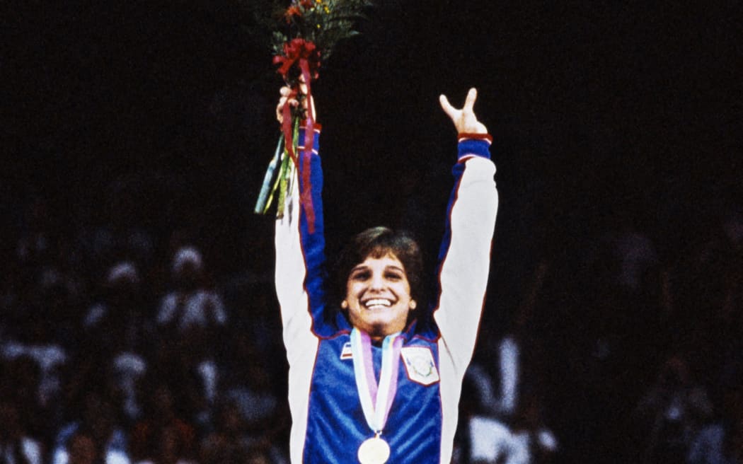 American gymnast Mary-Lou Retton waves on the podium after receiving her gold medal in women's individual all-around category, during the Summer Olympic Games at Los Angeles, 1984.