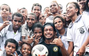 Wardstrip Demonstration Primary School students with a Solomon Kings FC player during the team's school visit in Port Moresby on Thursday. Photo: OFC