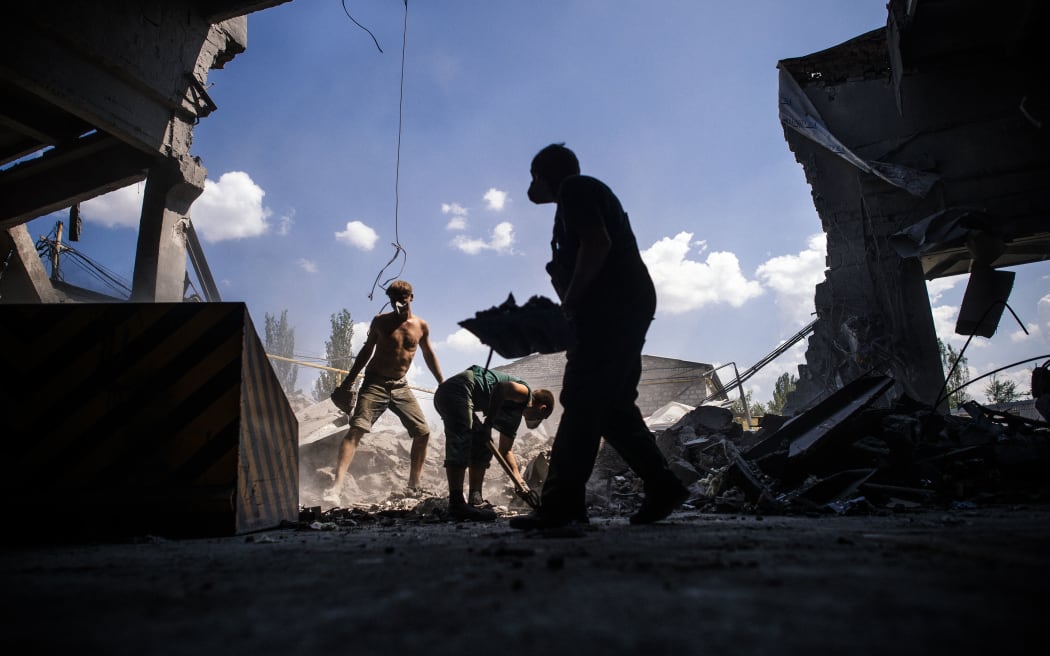 In the main rebel stronghold of Donetsk, men clean debris after what was said to to be an air strike.