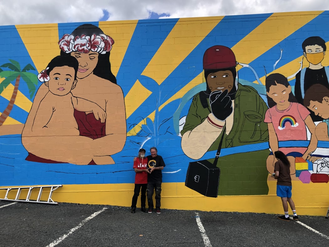Tigilau Ness and Chris McBride in front of the mural