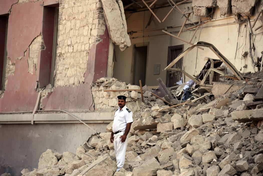 Egyptian policeman in the rubble of the Italian consulate in Cairo.