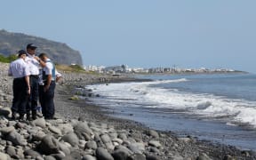 Police officers inspect metallic debris on the French Reunion Island in the Indian Ocean.