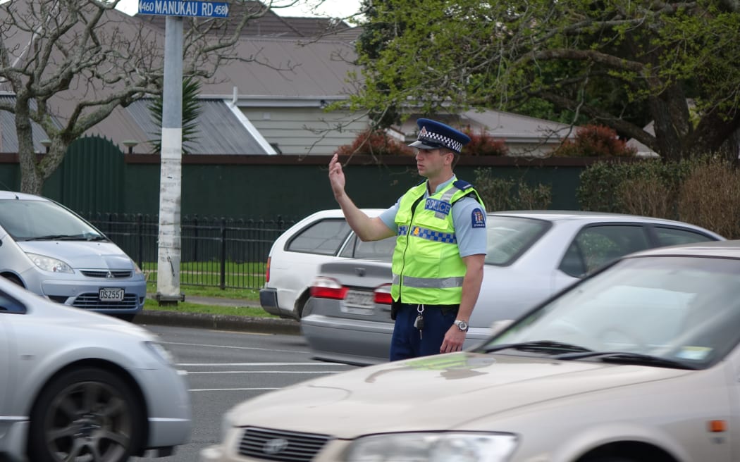 A police officer directs traffic at the intersection of Manukau and Greenlane Roads in Epsom.