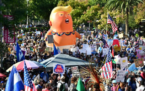 Protesters rally during the "No Kings" national day of protest in Los Angeles, California on October 18, 2025. From New York to San Francisco, millions of Americans are expected to hit the streets to voice their anger over President Donald Trump's policies at nationwide "No Kings" protests. (Photo by Frederic J. BROWN / AFP)