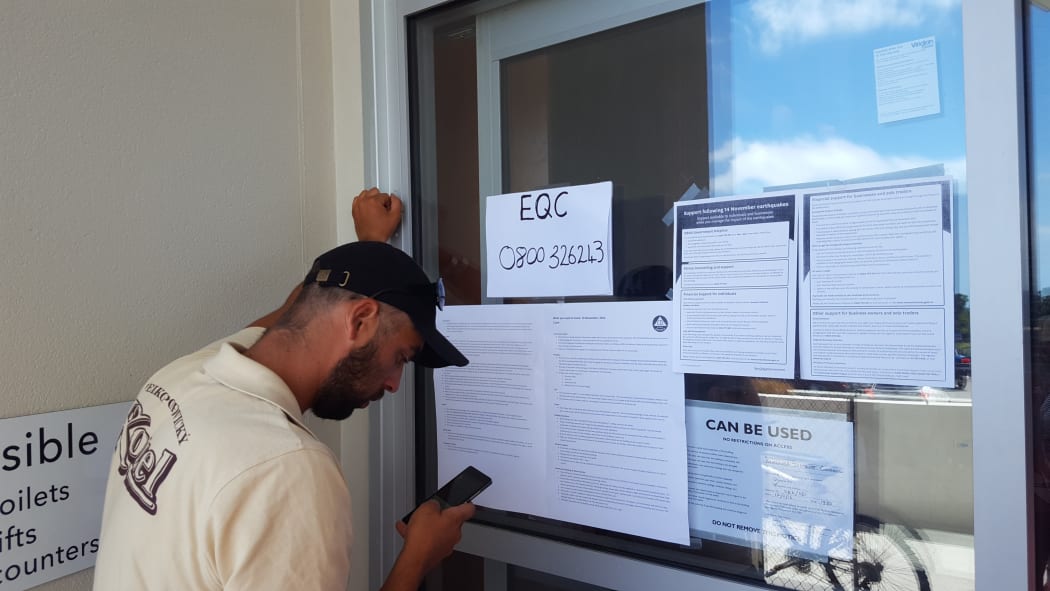 A Kaikoura local relays EQC information over the phone.