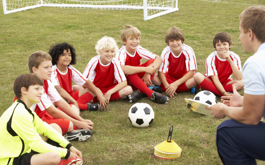 Junior football team training with coach