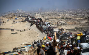 Palestinians from Gaza City move southwards with their belongings, on the coastal road near the Nuseirat refugee camp in the central Gaza Strip, on September 19, 2025. The Israeli military warned on September 19, that it will operate with "unprecedented force" in Gaza City, urging residents to flee southwards while announcing the closure of a temporary evacuation route opened 48 hours earlier. (Photo by Eyad BABA / AFP)