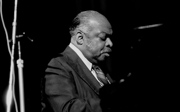 Count Basie sitting playing the piano