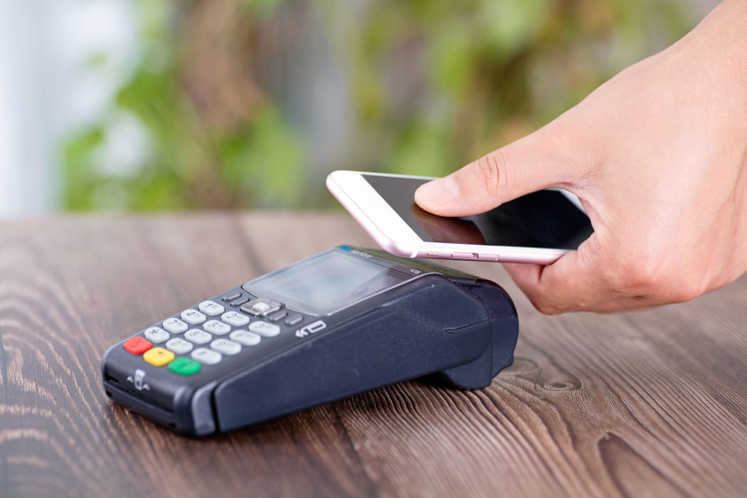 A mobile phone with a QR code is used to make a payment.