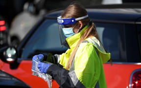A health worker registers a resident at a Covid-19 coronavirus drive through testing site on Bondi Beach in Sydney on June 17, 2021,