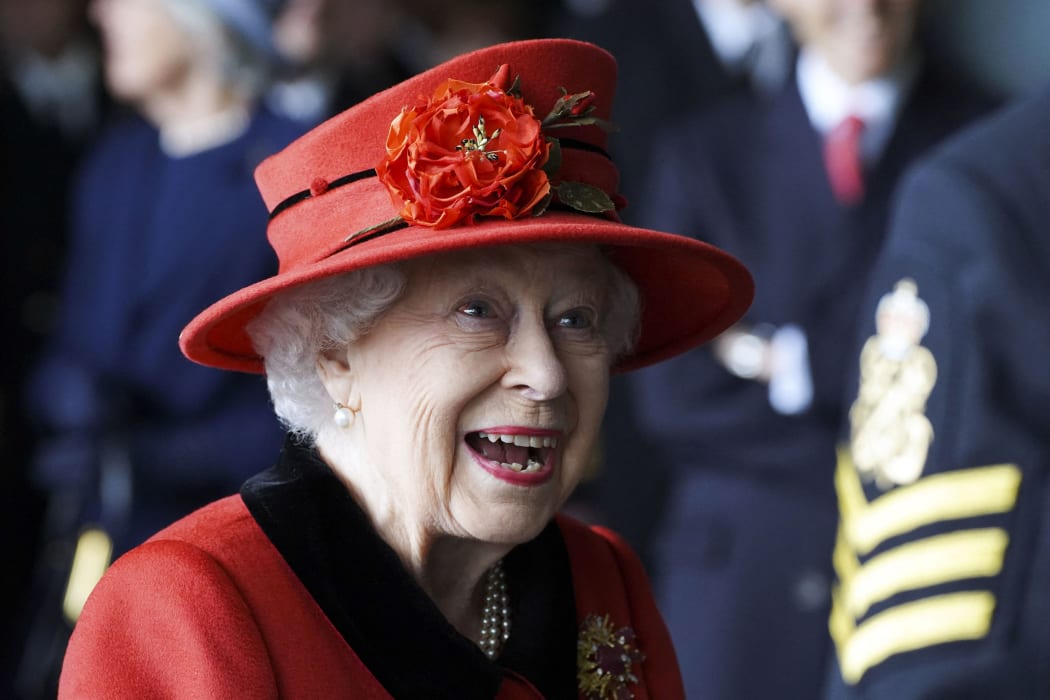 Britain's Queen Elizabeth II reacts as she meets military personnel during her visit to the aircraft carrier HMS Queen Elizabeth in Portsmouth, southern England on May 22, 2021.
