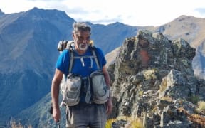 Image of Paul Roy tramping on mountain range.