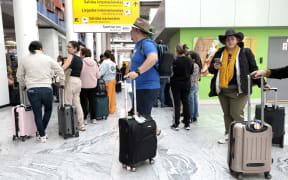 Passengers remain stranded at Guadalajara International Airport following flight suspensions and lack of transport in Tlajomulco, Jalisco State, Mexico, on February 22, 2026. Mexico confirmed on February 22 that soldiers killed a powerful drug cartel leader who was one of the most wanted men here and in the United States. Nemesio Oseguera, the 59-year-old leader of the violent Jalisco New Generation Cartel, was wounded in a clash with soldiers in the town of Tapalpa and died while being flown to Mexico City, the army said in a statement. (Photo by Ulises Ruiz / AFP)