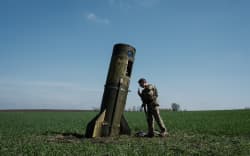 A Ukrainian serviceman looks at a Russian ballistic missile’s booster stage that fell in a field in Bohodarove, eastern Ukraine, on April 25, 2022.