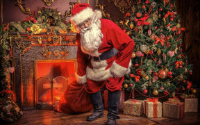Santa Claus bring the sack with gifts for Christmas. The house is beautifully decorated for Christmas.