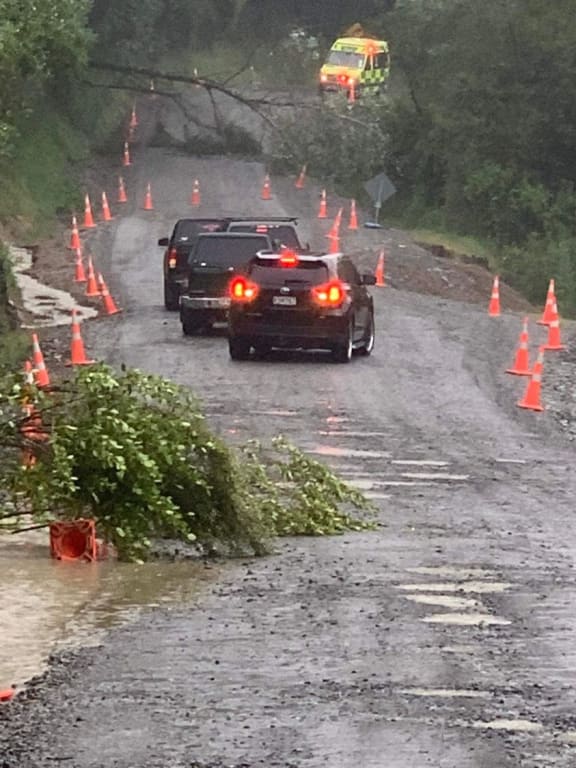 An ambulance winds its way past downed trees on a flooded alternate route while State Highway 35 was closed during heavy rain in October.