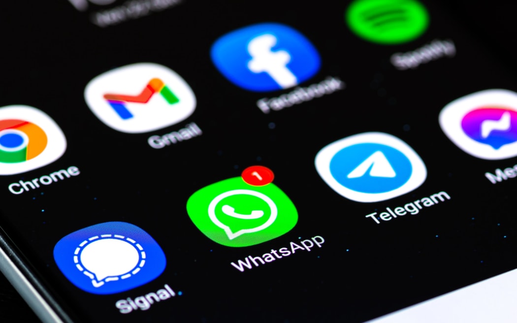 WhatsApp logo on screen alongside other apps.
