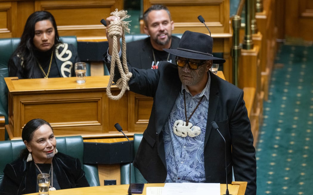 Rawiri Waititi speaks in the debate on the Privileges Committee's majority recommendation of parliamentary suspensions for three Te Pāti Māori MPs. The noose is a reference to a tupuna who was hanged in Mount Eden Prison.