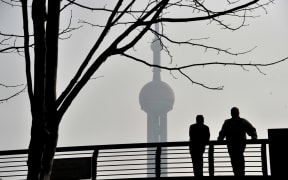 Local residents walk on the Waibaidu Bridge against skyline of the Lujiazui Financial District with the Shanghai Tower in heavy smog in Pudong, Shanghai, China, on 11 March 2019.