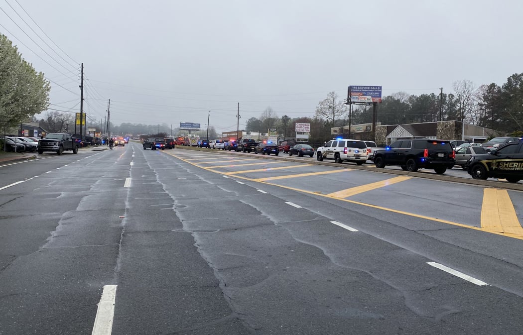 A line of law enforcement cars block the area of a shooting at a spa in an Atlanta suburb.