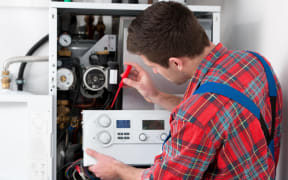 Technician servicing the gas boiler for hot water and heating