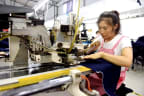Da Yanyan, a villager from Dongliuzhuang village of Nanhe County, north China's Hebei Province, makes clothes at a local anti-poverty factory,