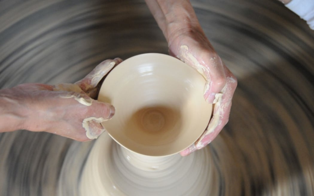 eteran craftsman Wang Yansheng does throwing on a potters' wheel in an old kiln in Jingdezhen City, east China's Jiangxi Province.