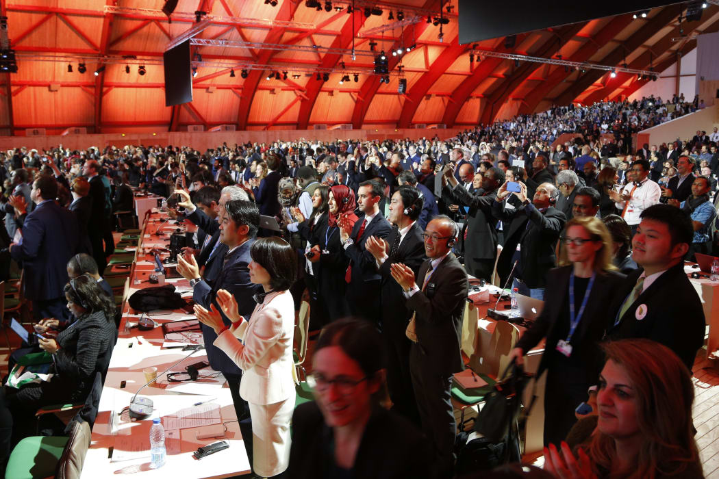 Delegates at the UN Climate Change Conference break into cheers as the Paris Agreement is adopted.